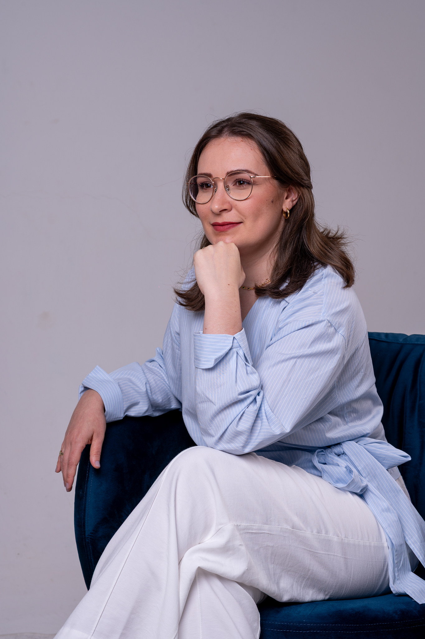 Eduarda Tartari sentada em poltrona azul