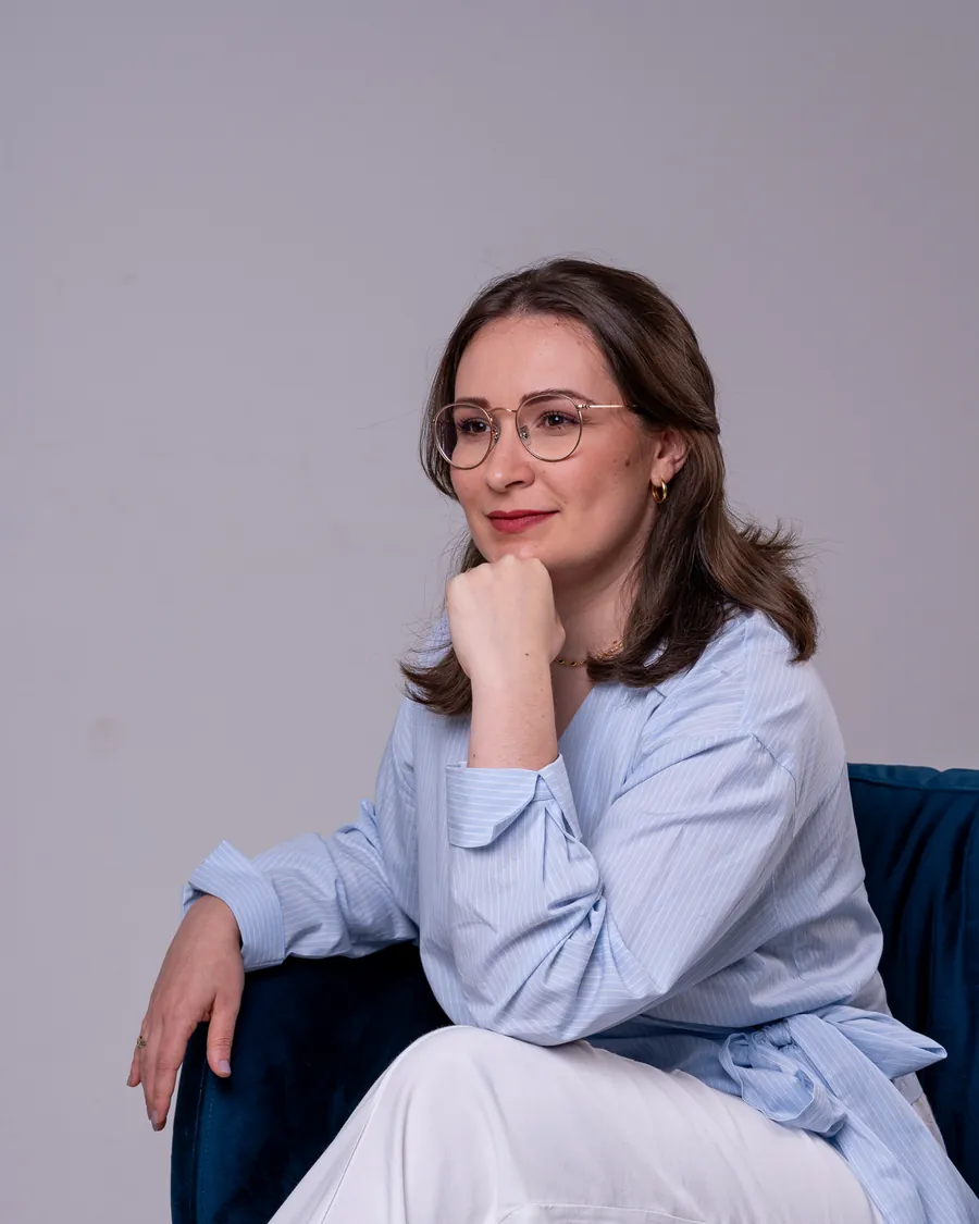 Eduarda Tartari sentada em poltrona azul